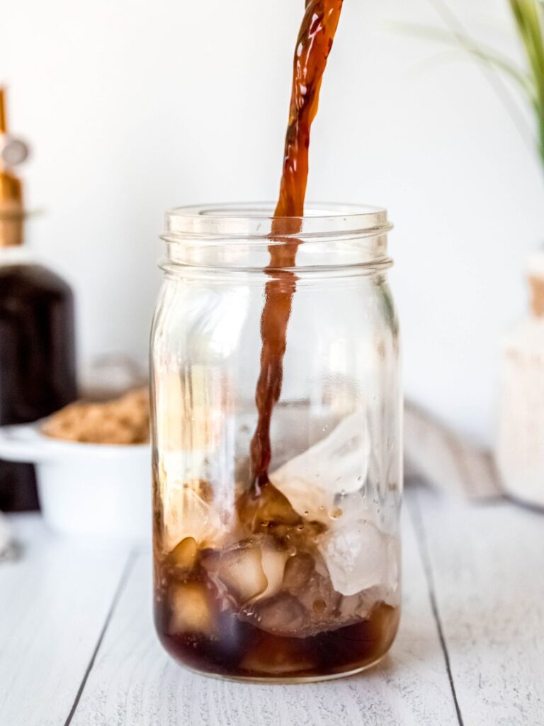 action shot of pouring espresso into a mason jar with ice.