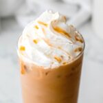 square hero image of Starbucks copycat caramel iced coffee topped with whipped cream and caramel sauce.