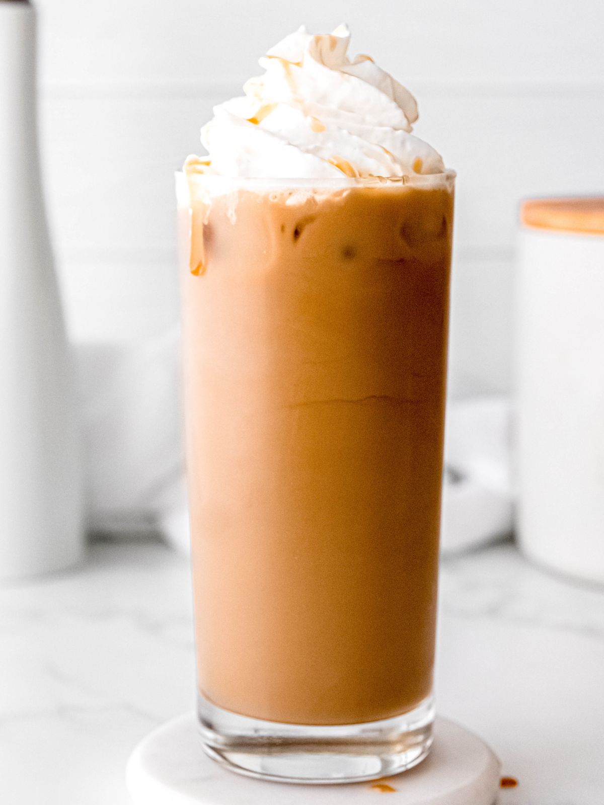 side on hero shot of an iced caramel coffee with whipped cream.