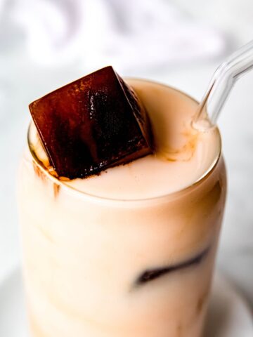 45 degree hero image of a glass of milk with coffee ice cubes making a reverse iced latte.