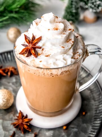45 degree angle image of an eggnog latte topped with whipped cream, nutmeg, and a whole star anise for garnish.