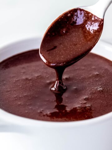 closeup shot of a spoon drizzling some of the mocha sauce back into the bowl to show how thick and yummy it is.