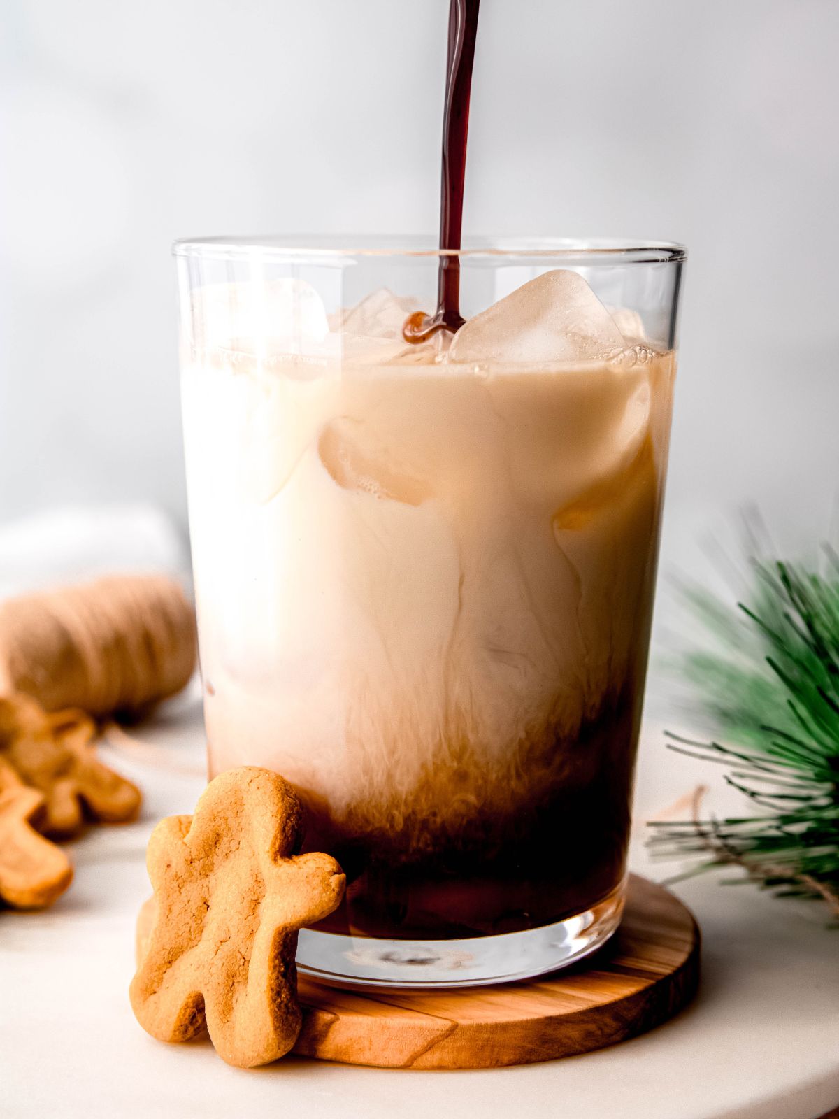 Pouring the gingerbread syrup into a glass with milk and coffee.