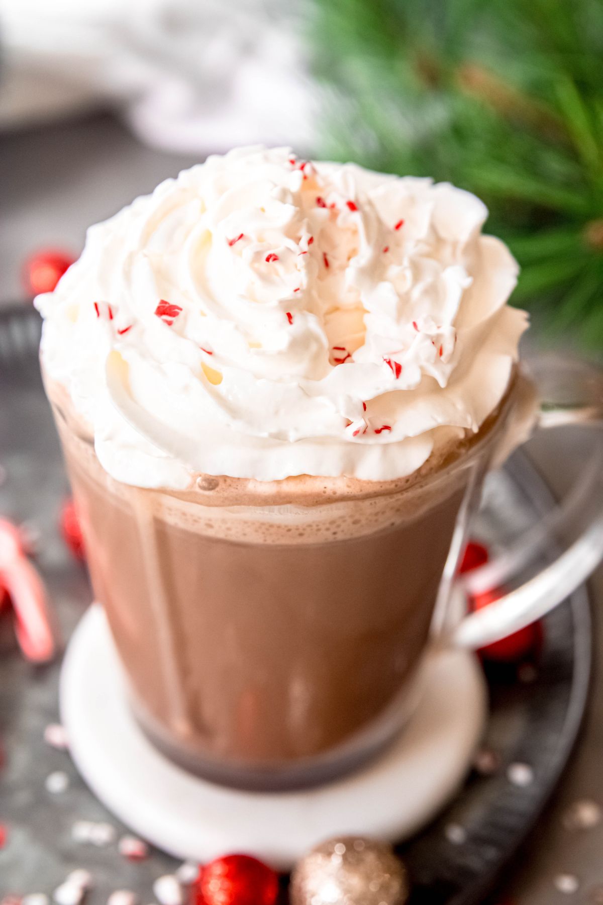 45 degree angle shot of a hot peppermint mocha topped with whipped cream and crushed candy canes.