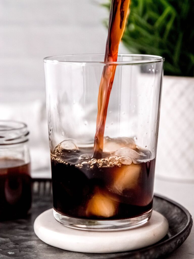 Pouring cold brew into a glass with ice. 