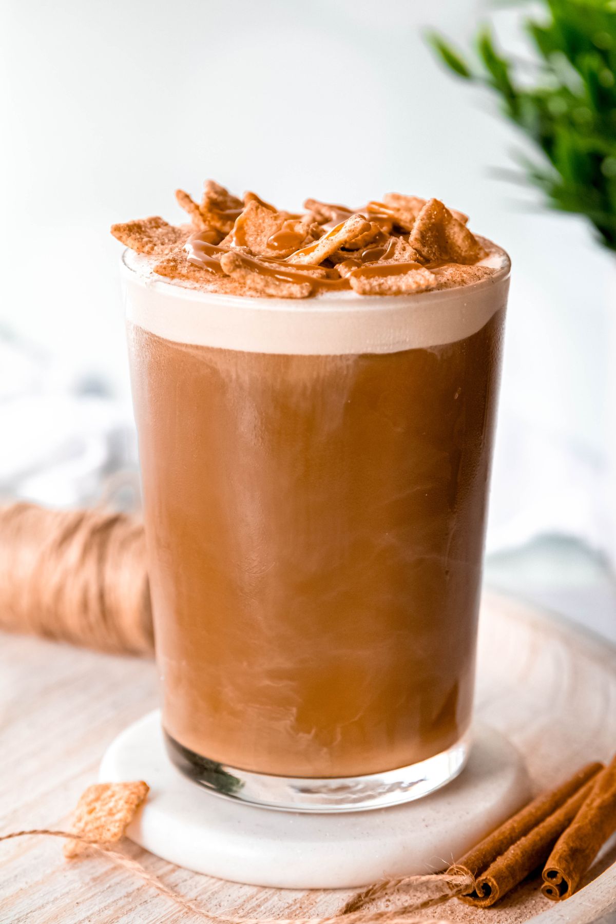 A close up shot of a tall glass of copycat Starbucks cinnamon caramel cream cold brew topped with cinnamon toast crunch and caramel.