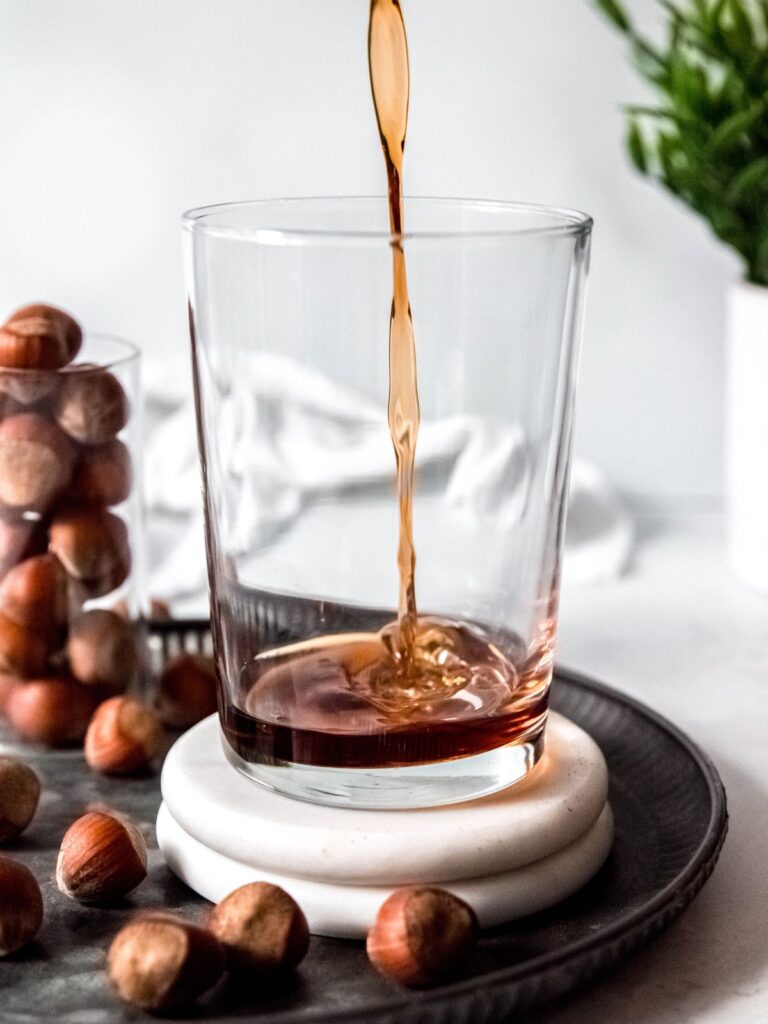 process shot - pouring hazelnut syrup in a glass.