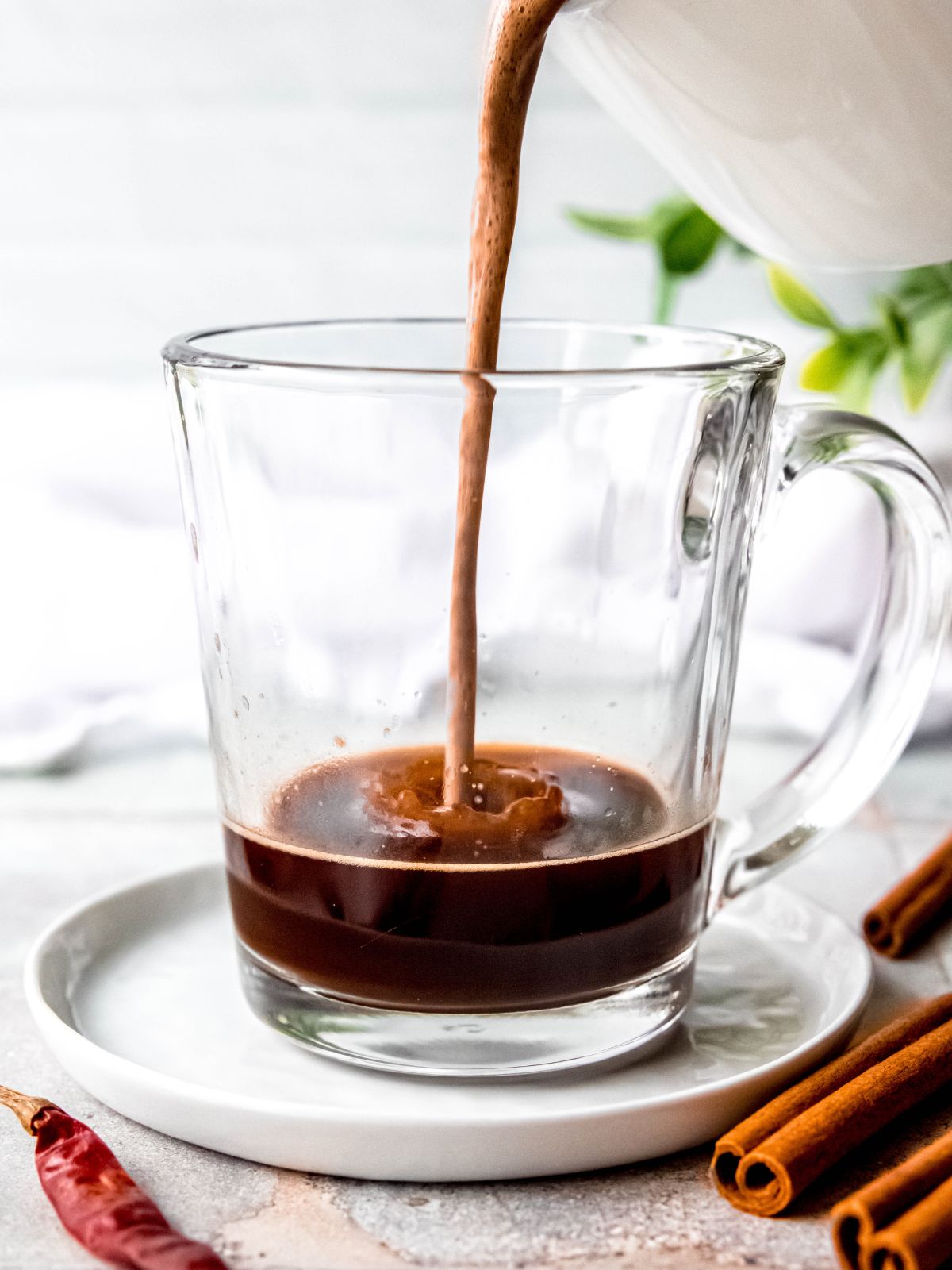 Pouring the Mexican hot chocolate mixture into the mug with the shot of espresso.