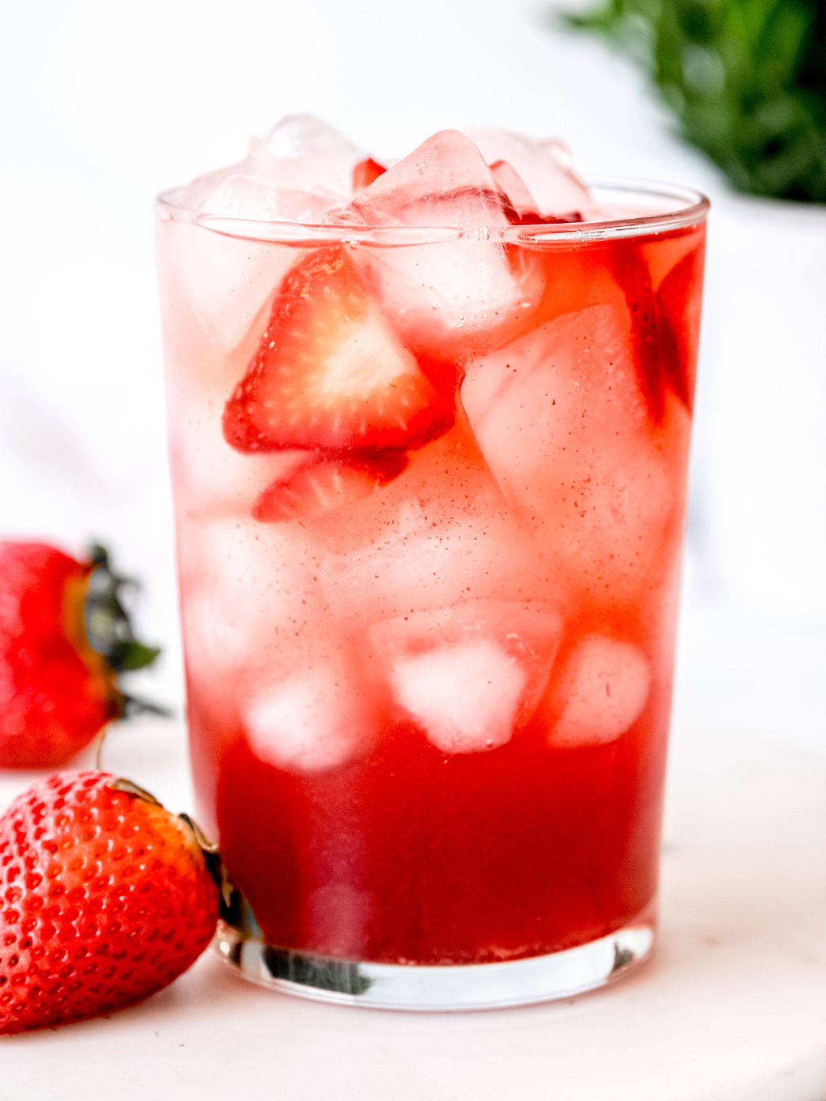 strawberry acai refresher garnished with fresh strawberry slices. 