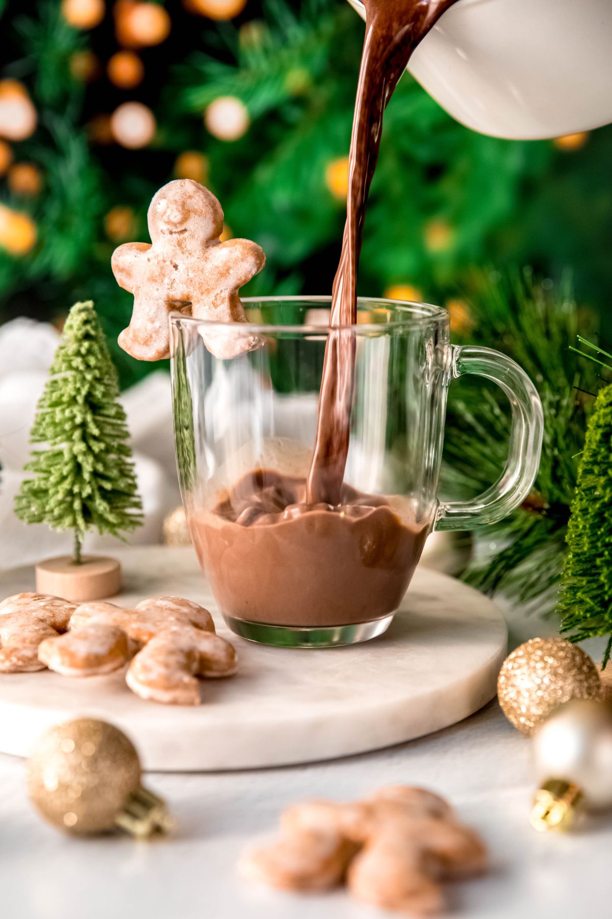 Pouring the gingerbread hot cocoa into a glass mug.