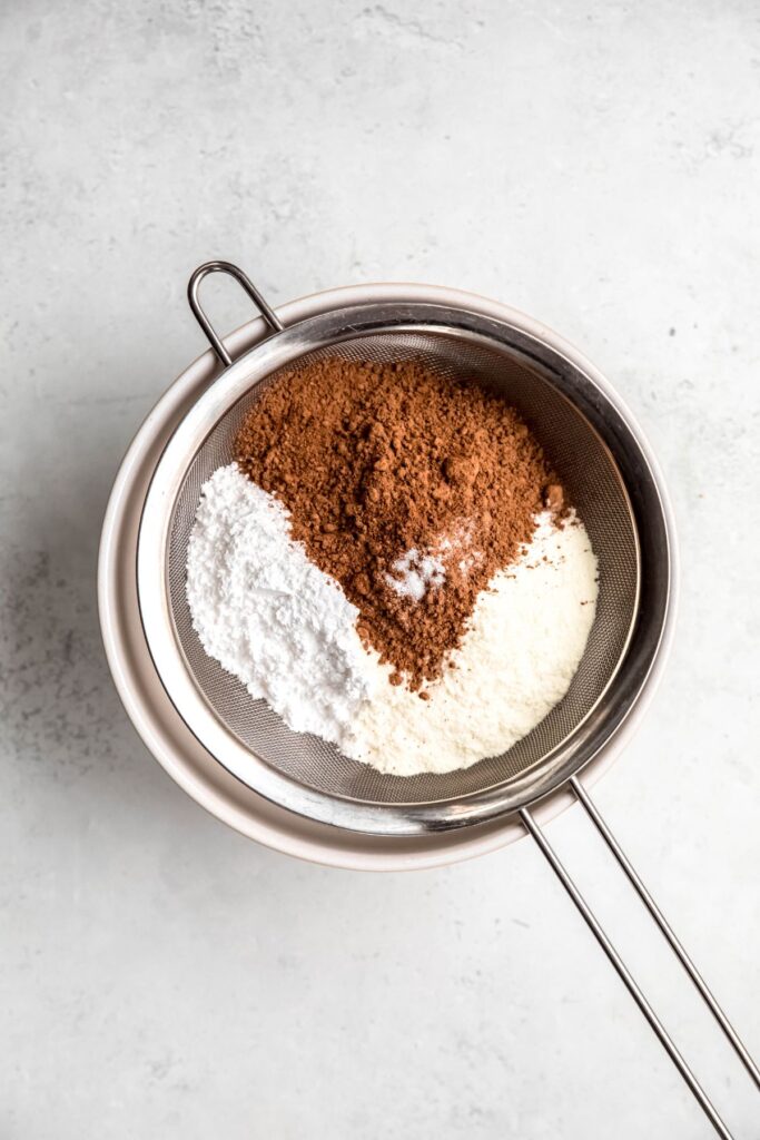 The hot cocoa mix ingredients added to a wire mesh before sifting.