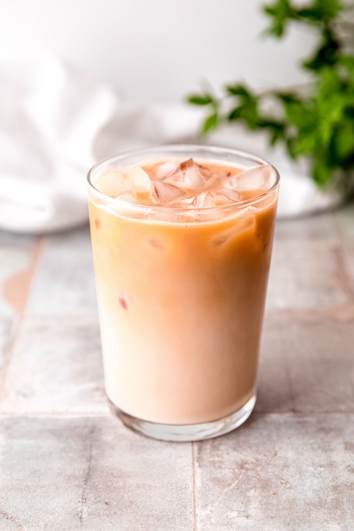 A close-up shot of a glass of stirred vanilla protein iced coffee on the counter. 