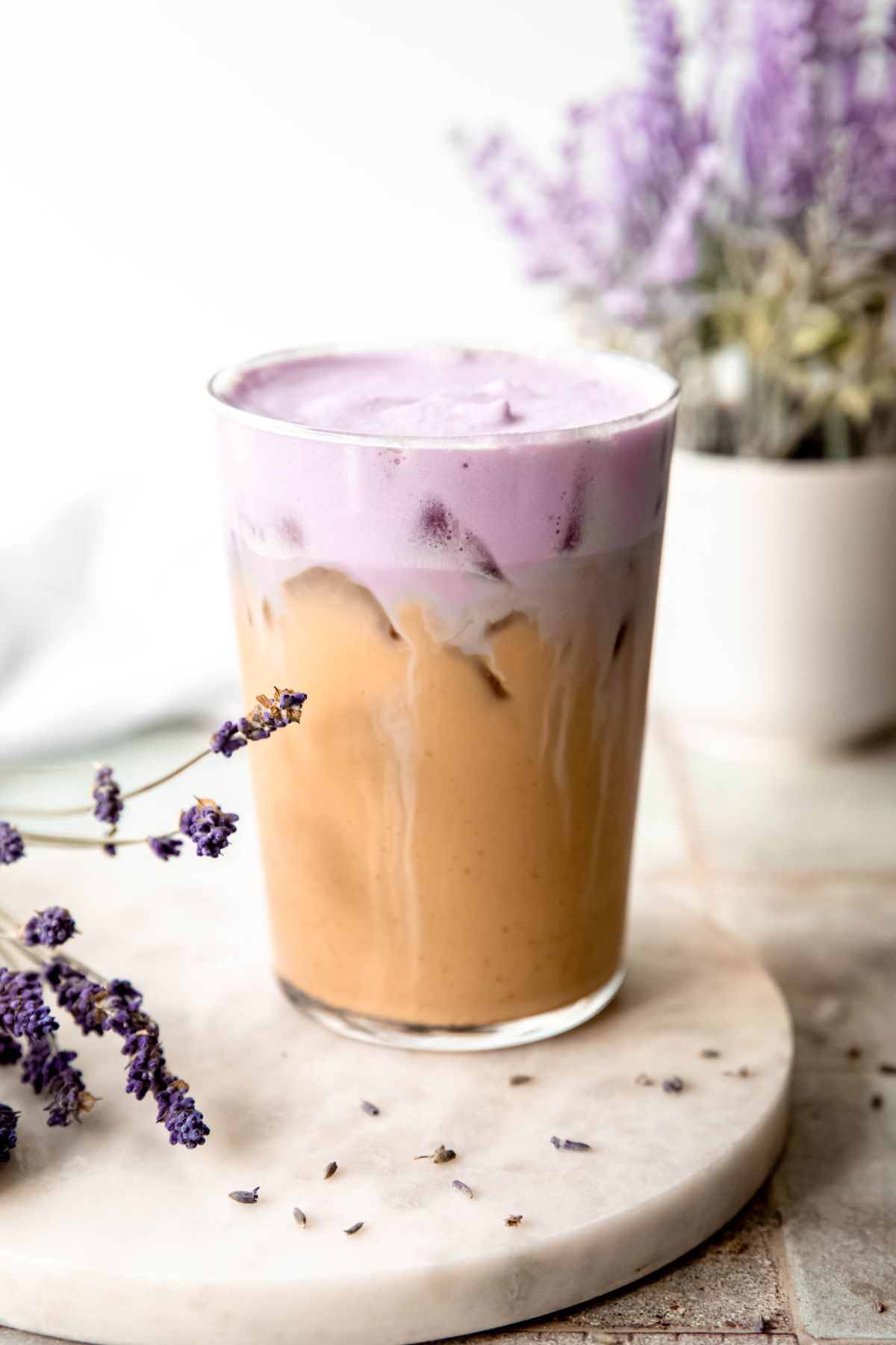 A close-up side shot of a glass of Iced Lavender Cream Chai. 
