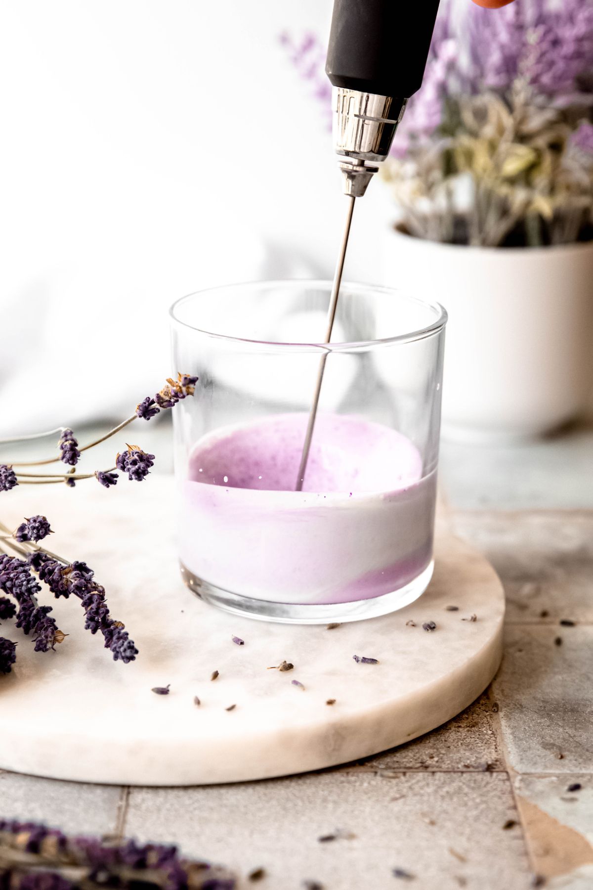 action shot showing the lavender cold foam ingredients as the milk frother starts to froth it. 