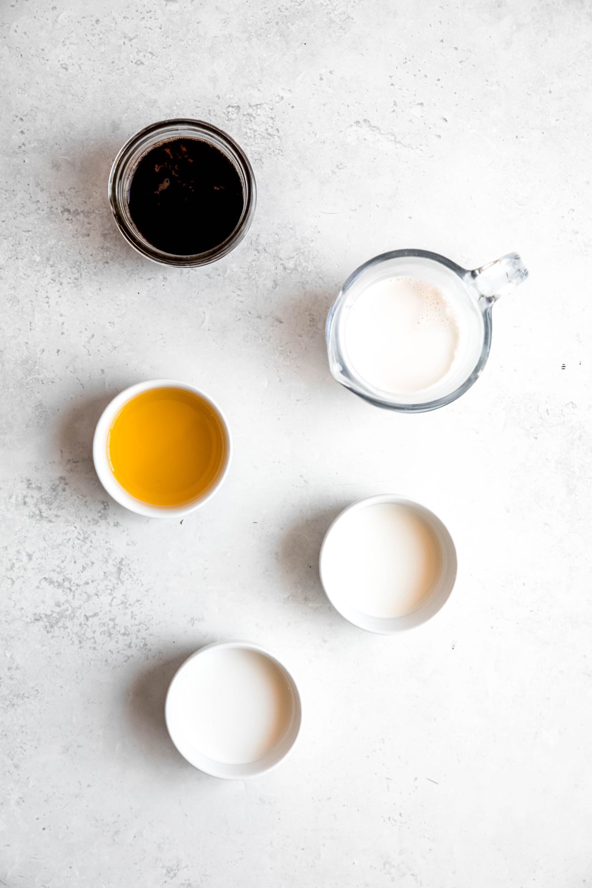 ingredients needed to make a copycat Starbucks iced mango cream chai tea latte recipe measured out on a white table. 