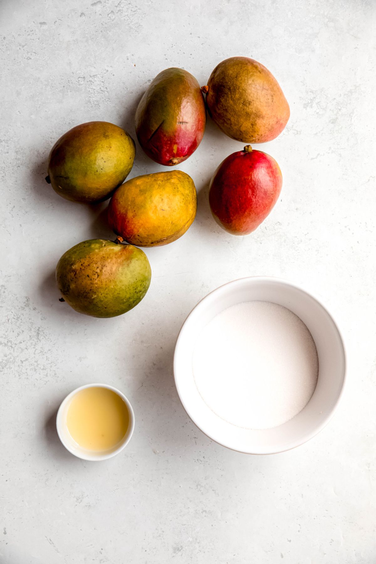 mangoes, sugar, and lemon juice measured out for making homemade mango syrup for drinks. 