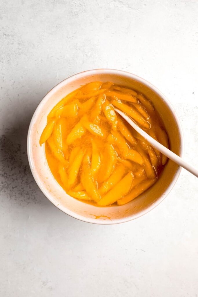 macerated mango slices swimming in syrup after resting. 