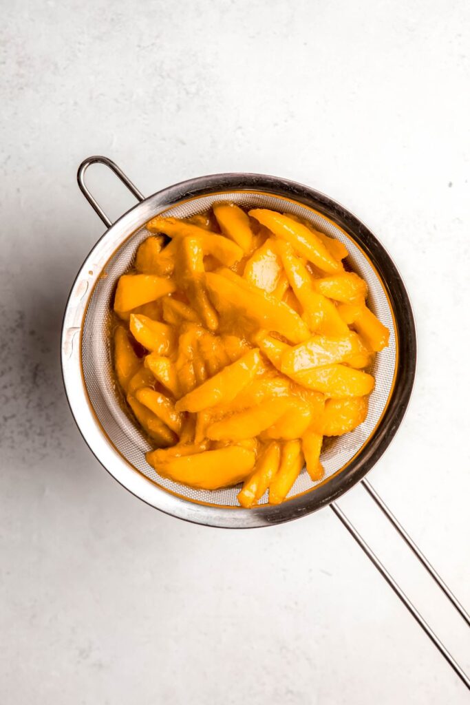 macerated mango slices strained from the syrup using a mesh strainer. 