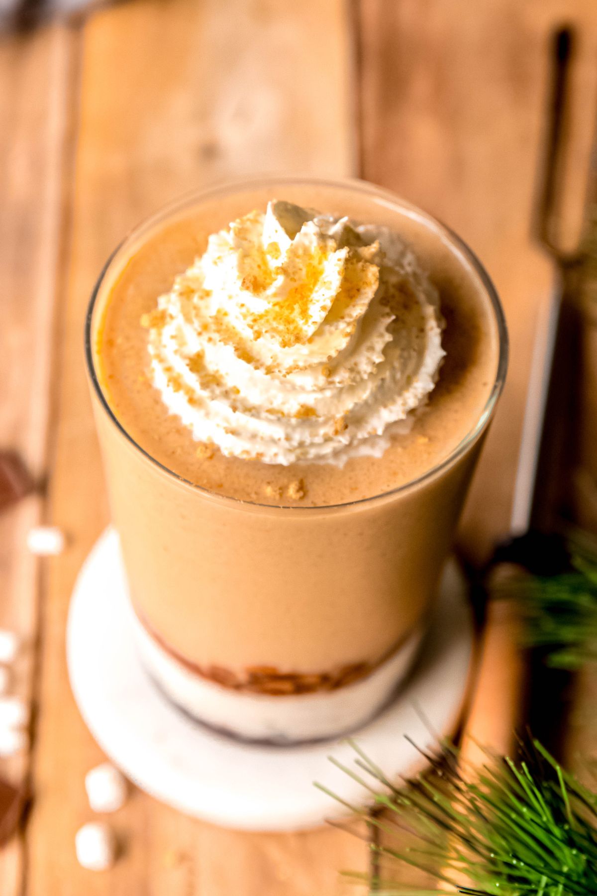 45 degree overhead shot of a homemade starbucks s'mores frappe topped with whipped cream and graham cracker bits. 
