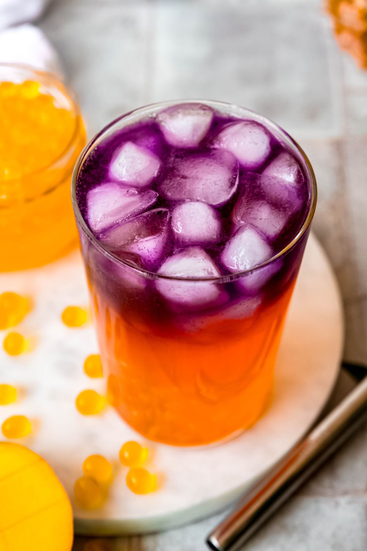 45 degree overhead shot of a DIY starbucks tropical butterfly refresher showing the ombre color shift from magenta to orange.