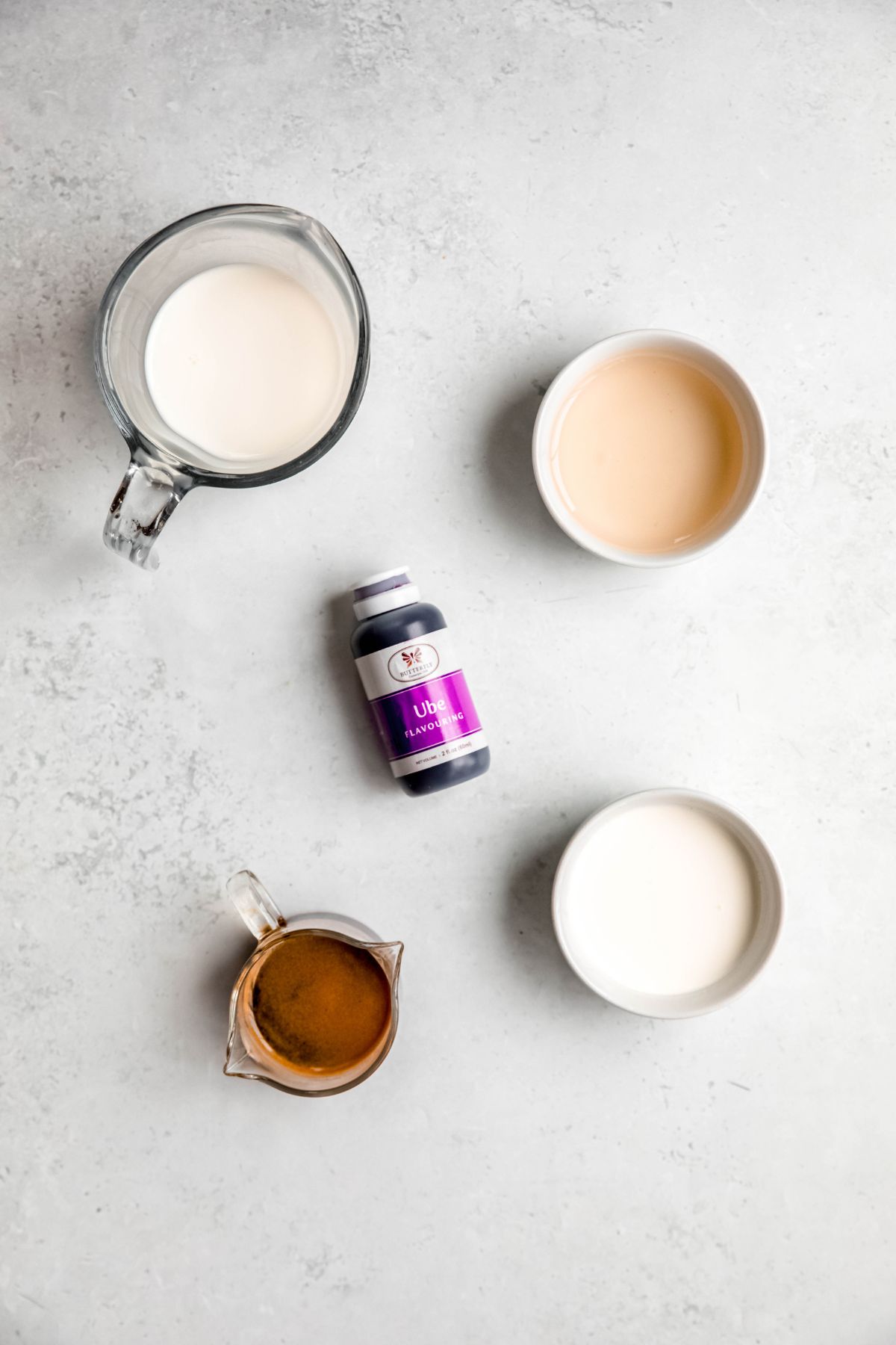 ingredients needed to make a copycat Starbucks iced ube coconut cream shaken espresso recipe at home measured out on a white table. 