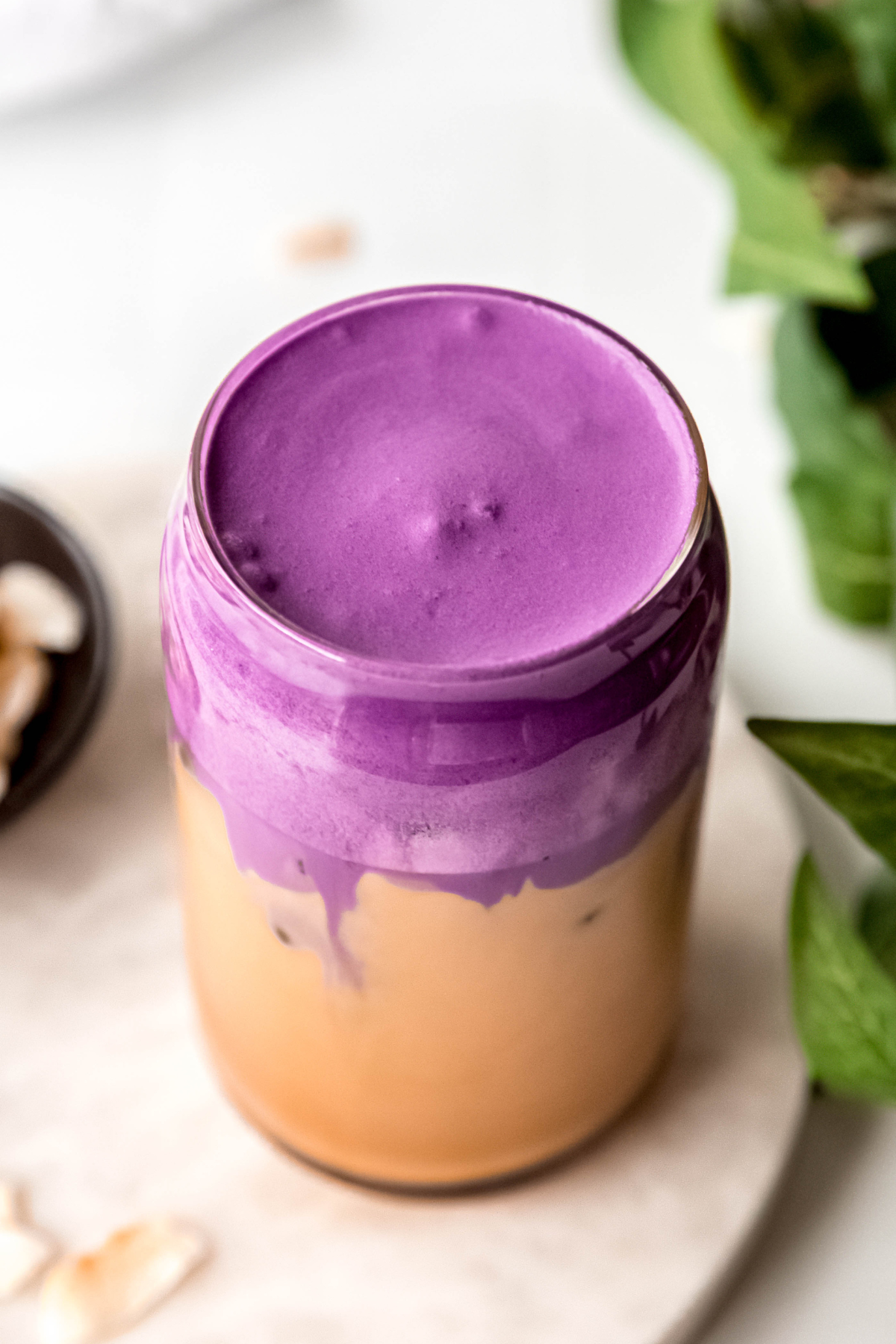 45 degree overhead shot of an iced ube coconut cream shaken espresso showing the vibrant violet color and creamy consistency of the ube coconut cream cold foam topping the shaken espresso. 